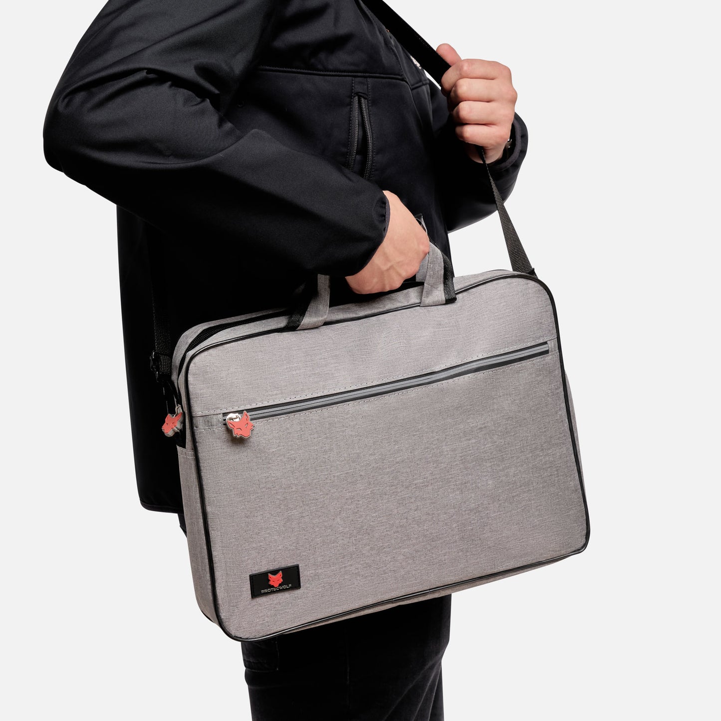 Person holding a gray laptop bag with a visible brand logo on a white background