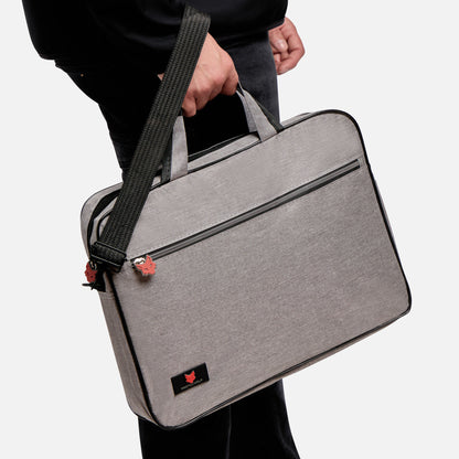 Person holding a gray laptop bag with a black strap on a white background