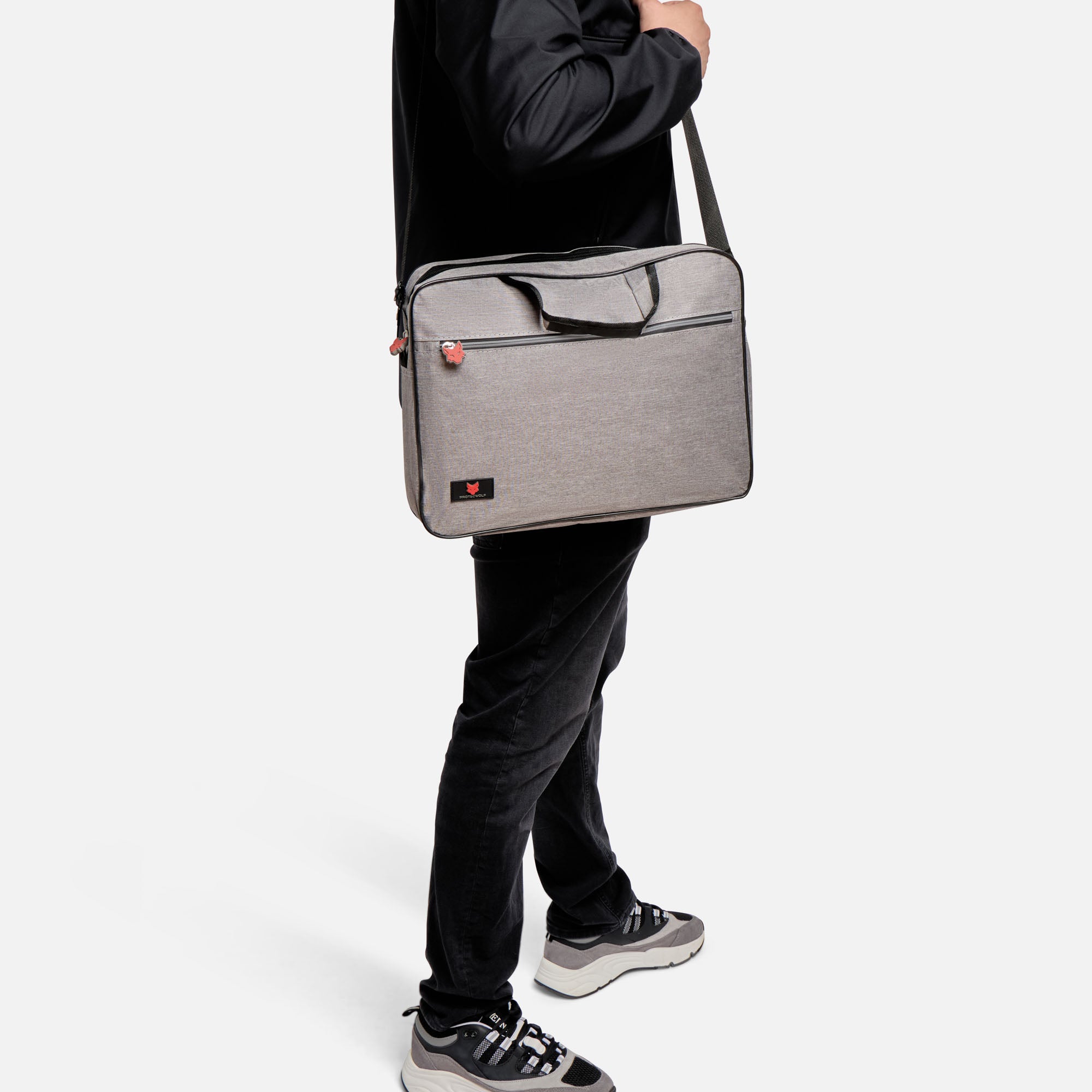 Person holding a gray laptop bag on a white background
