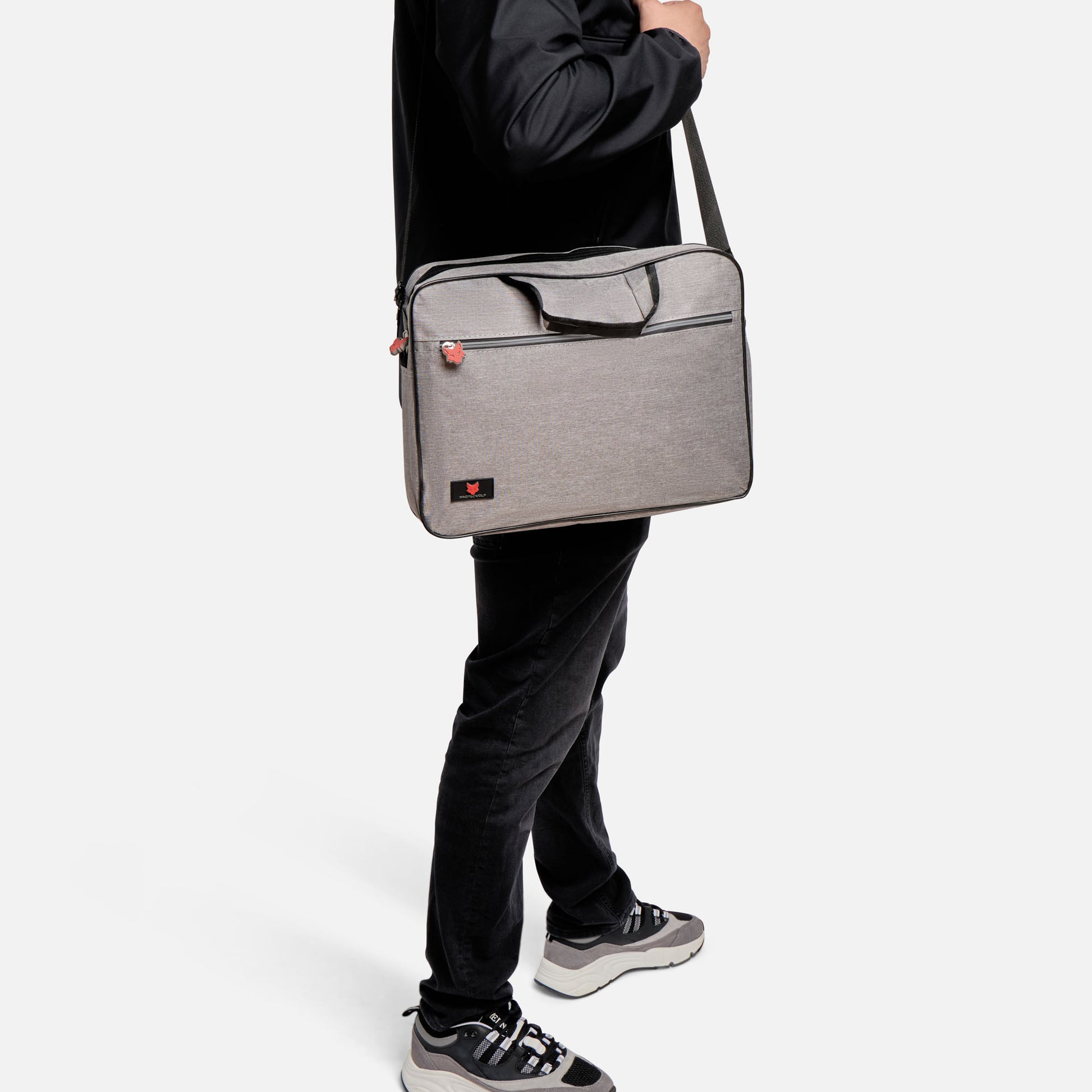 Person holding a gray laptop bag on a white background