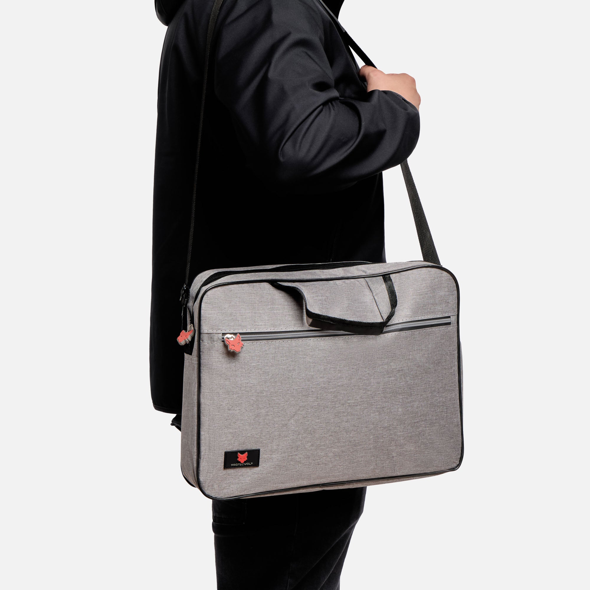 Person holding a gray shoulder bag against a white background