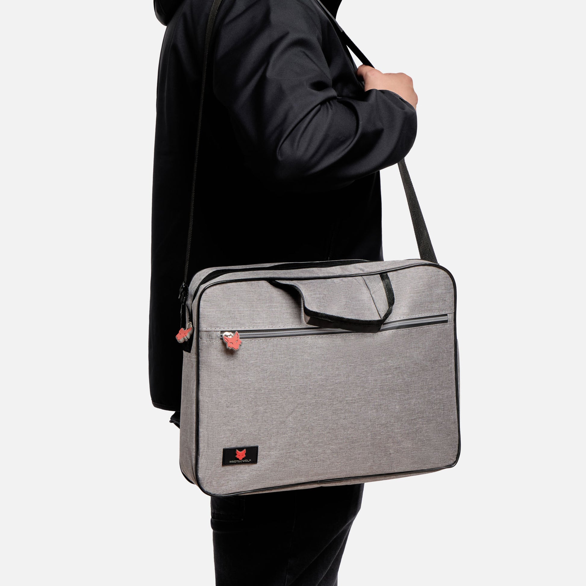 Person holding a gray shoulder bag against a white background