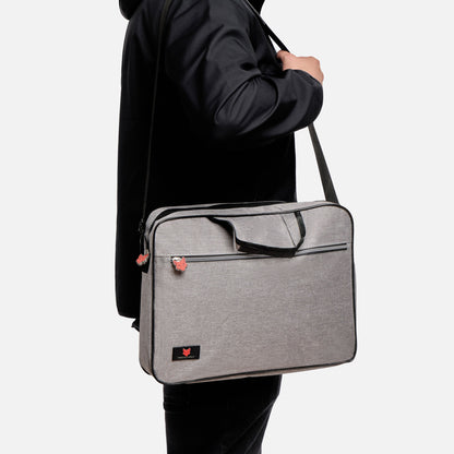 Person holding a gray shoulder bag against a white background