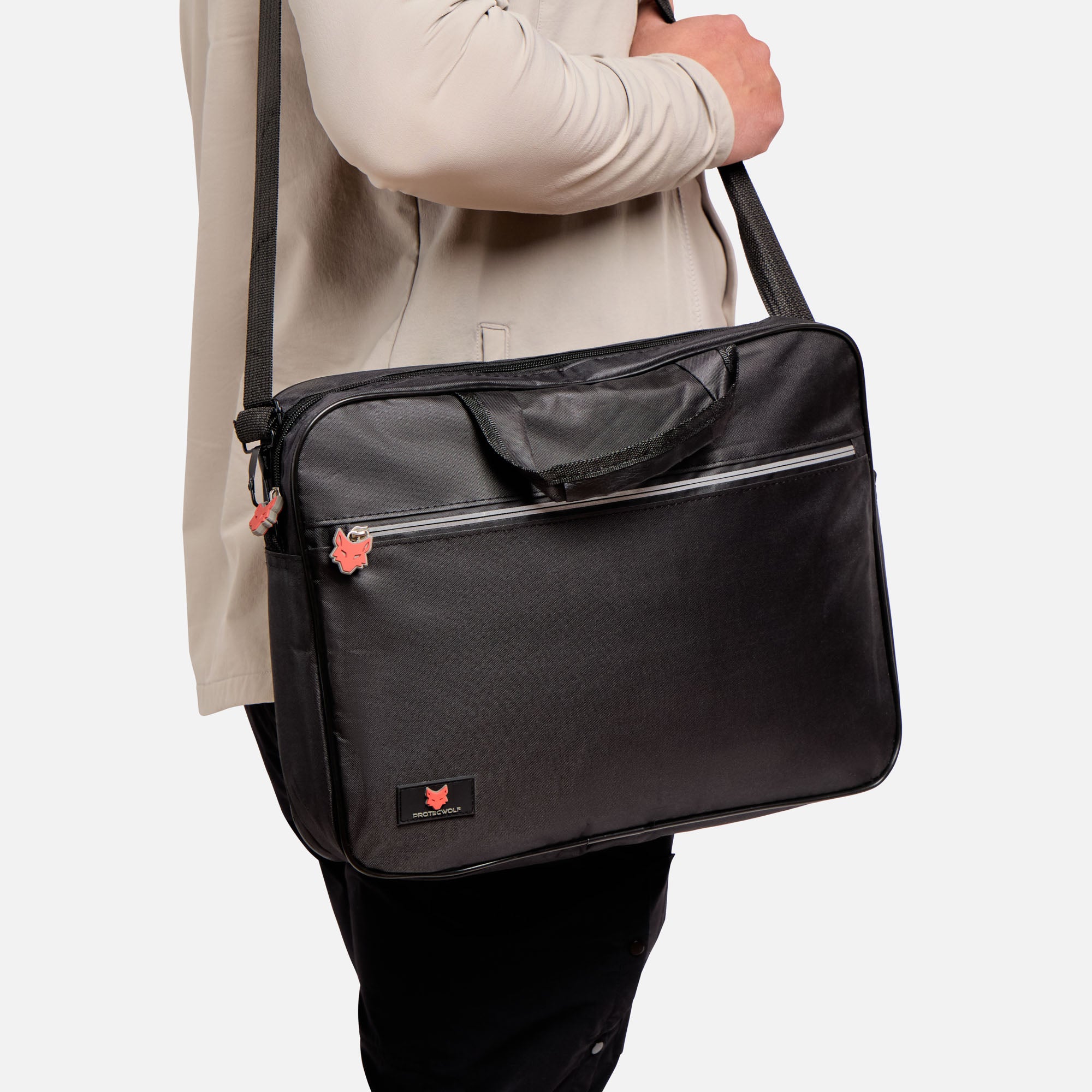 Person carrying a black shoulder bag on a light gray background