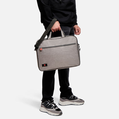 Person holding a gray briefcase against a white background